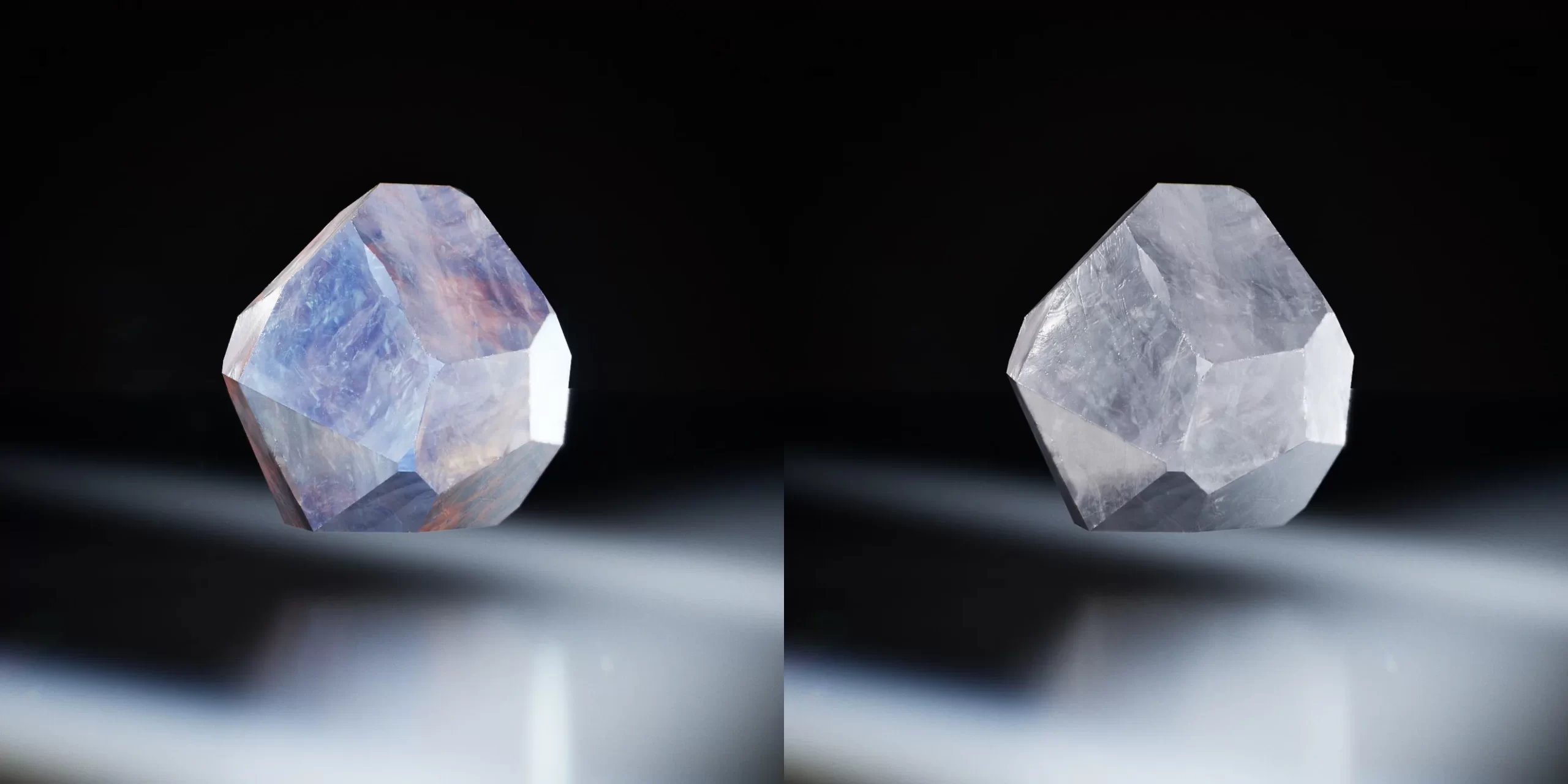 蓝紫与浅灰白水晶对比 黑色背景上并排两颗多面水晶,左侧带蓝紫色纹理,右侧接近浅灰白色